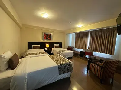 a hotel room with two beds and a table at El Tambo 1 in Lima