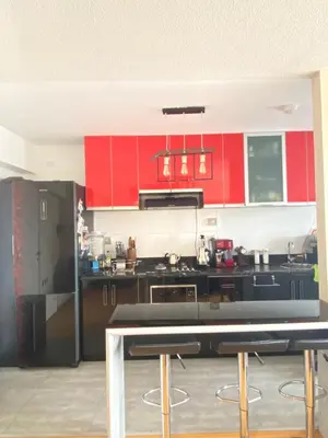 a kitchen with red cabinets and a black counter top at HABITACIÓN EN EDIFICIO CENTRO COLONIAL- Cerca al centro histórico in Lima