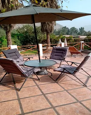 two chairs and a table with an umbrella on a patio at Casa El Palto in Santa Eulalia