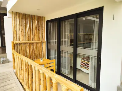 a balcony with black doors and a wooden table at Jalara hotel Boutique Lunahuaná in Lunahuaná
