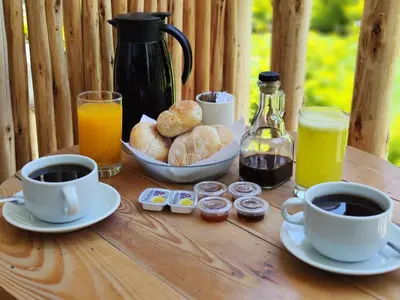 a table with two cups of coffee and a plate of pastries at Jalara hotel Boutique Lunahuaná in Lunahuaná
