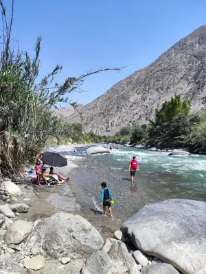 a group of people walking in the water on a river at Jalara hotel Boutique Lunahuaná in Lunahuaná