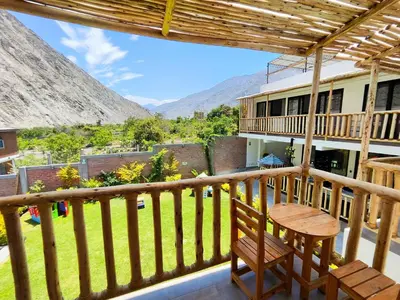 a balcony with a table and a view of the mountains at Jalara hotel Boutique Lunahuaná in Lunahuaná