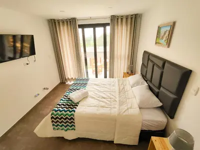 a bedroom with a large bed and a large window at Jalara hotel Boutique Lunahuaná in Lunahuaná