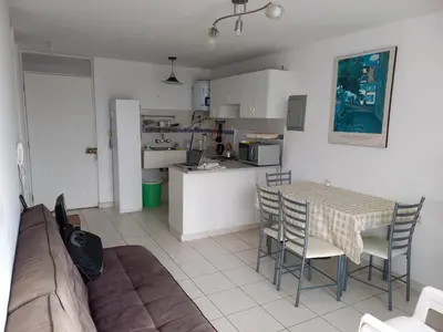 a living room with a table and chairs and a kitchen at Minidepartamento en San Bartolo - VISTA AL MAR in San Bartolo