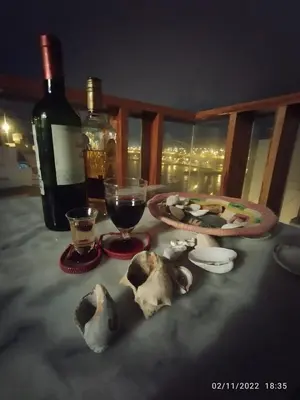 a table with a bottle of wine and a plate of food at Minidepartamento en San Bartolo - VISTA AL MAR in San Bartolo