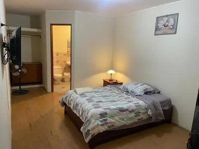 a bedroom with a bed and a television in it at Entre Cava y Cata in Ica