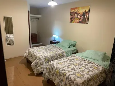 a room with two beds and a picture on the wall at Entre Cava y Cata in Ica