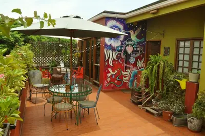 a patio with a table and chairs and an umbrella at Casa Nuestra Peru in Lima