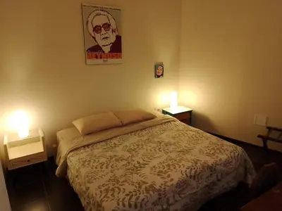 a bedroom with a bed and two lights on two tables at Casa Nuestra Peru in Lima