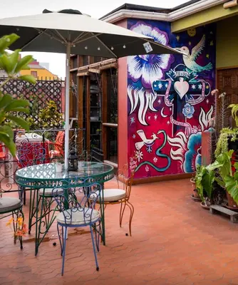 a table and chairs with an umbrella on a patio at Casa Nuestra Peru in Lima