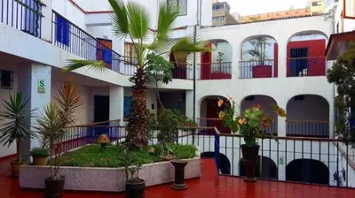 a building with a courtyard with palm trees and plants at Centric, private, petfriendly apartments in Miraflores in Lima
