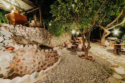 a garden with a tree and a stone wall at Hotel Vallehermoso in Cotahuasi