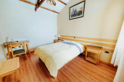 a bedroom with a bed and a wooden floor at Hotel Vallehermoso in Cotahuasi