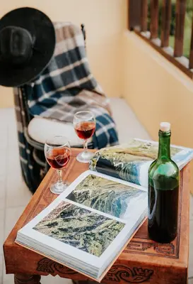 a table with two glasses and a bottle of wine at Hotel Vallehermoso in Cotahuasi