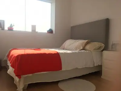 a bedroom with a bed with a red and white blanket at Precioso cuarto dentro de un apartamento centrico compartido in Lima