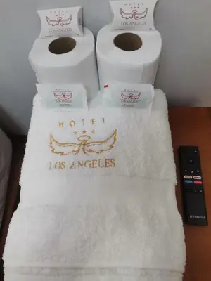 three rolls of toilet paper on a table with a remote control at Hotel los angeles in Huaral