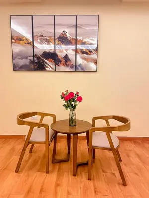 a table with two chairs and a vase with flowers at SM HOTEL Plus in Lima