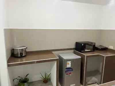 a room with three counters with a microwave and a refrigerator at MH Apartments Ica in Ica