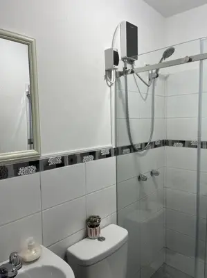 a bathroom with a shower and a toilet and a sink at MH Apartments Ica in Ica