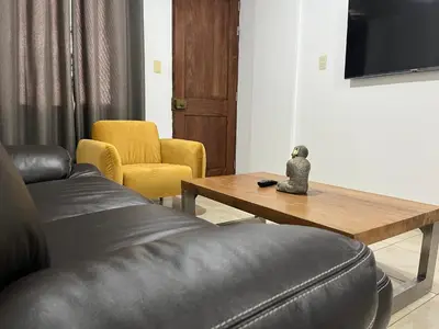 a living room with a leather couch and a wooden table at MH Apartments Ica in Ica