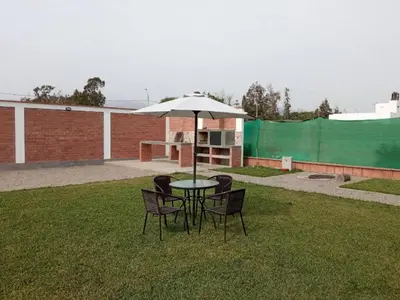 a table and chairs with an umbrella in the grass at Country House In Asia in Asia