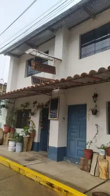 a building with a blue door and a sign on it at Hospedaje Quillabamba in Santa Teresa