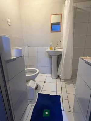 a white bathroom with a toilet and a sink at Hospedaje Quillabamba in Santa Teresa