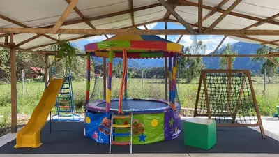 a colorful playground with a slide and a play structure at Cabañas - Kobold Haus in Oxapampa