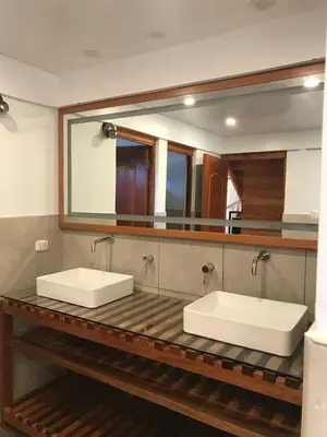 a bathroom with two sinks and a large mirror at Cabañas - Kobold Haus in Oxapampa