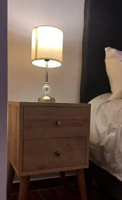 a lamp on a night stand next to a bed at Gorgeous Private Studio LIMA-Own Bathroom-Near Airport in Lima
