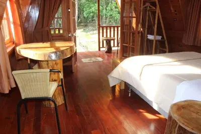 a bedroom with a bed and a table and a chair at Oxablues Home Lodge in Oxapampa