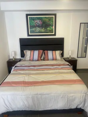 a bedroom with a large bed with two night stands at (10) Departamento de estreno centro de Mirafores in Lima