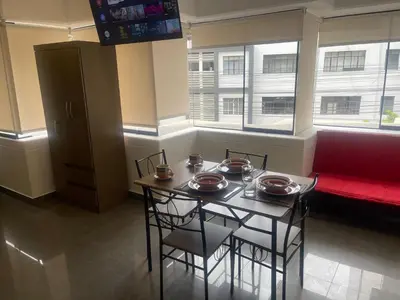 a dining room with a table and chairs and a red couch at (10) Departamento de estreno centro de Mirafores in Lima