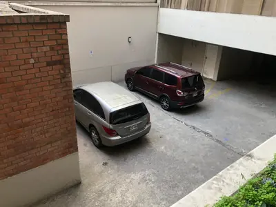 two cars are parked in a parking lot at (11) Nuevo y acogedor departamento en Miraflores. in Lima