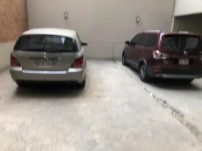 two cars are parked in a garage at (11) Nuevo y acogedor departamento en Miraflores. in Lima