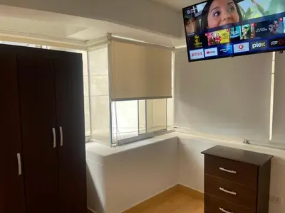 a room with a window and a tv on the wall at 13 Nuevo y acogedor departamento en Miraflores in Lima