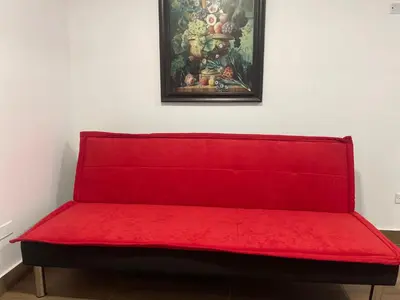 a red bench in a room with a painting on the wall at 13 Nuevo y acogedor departamento en Miraflores in Lima
