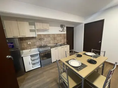 a small kitchen with a table and a table and chairs at 13 Nuevo y acogedor departamento en Miraflores in Lima