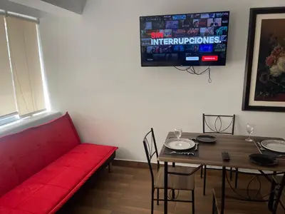 a living room with a red couch and a table at 14 Departamento acogedor y nuevo en Miraflores in Lima
