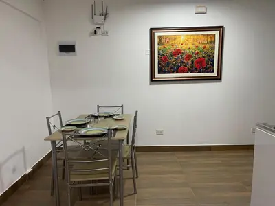 a dining room with a table and a painting on the wall at 15 Acogedor dpto de un ambiente en miraflores in Lima
