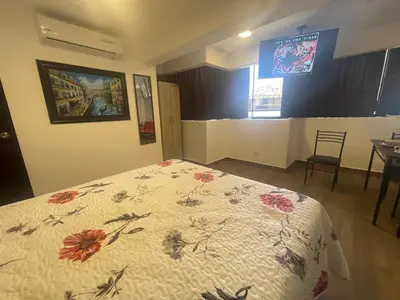 a bedroom with a bed with a comforter with flowers on it at 15 Acogedor dpto de un ambiente en miraflores in Lima