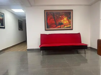 a red bench in a room with a painting on the wall at 16 Dpto con inmejorable ubicación en Miraflores in Lima