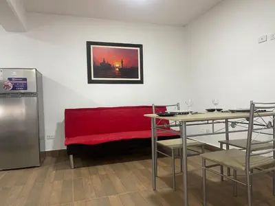 a living room with a red couch and a table at 16 Dpto con inmejorable ubicación en Miraflores in Lima