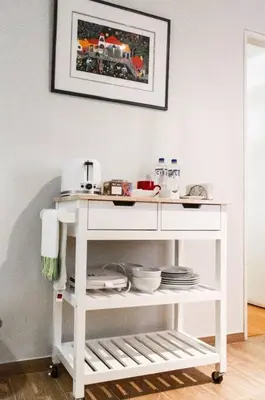 a white kitchen cart with a train picture on the wall at Confortable and functional apartment in MIRAFLORES ! in Lima