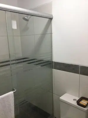 a bathroom with a glass shower door next to a toilet at Confortable and functional apartment in MIRAFLORES ! in Lima