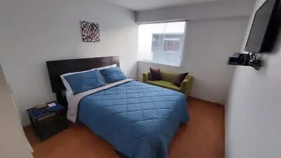 a small bedroom with a bed and a chair at Confortable and functional apartment in MIRAFLORES ! in Lima