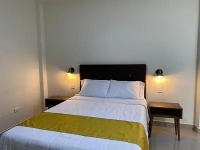 a bedroom with a large bed with two night stands at Hotel Alba in Ica