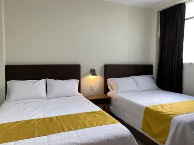 two beds sitting next to each other in a bedroom at Hotel Alba in Ica