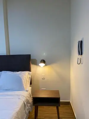 a bedroom with a bed with a wooden table next to it at Hotel Alba in Ica